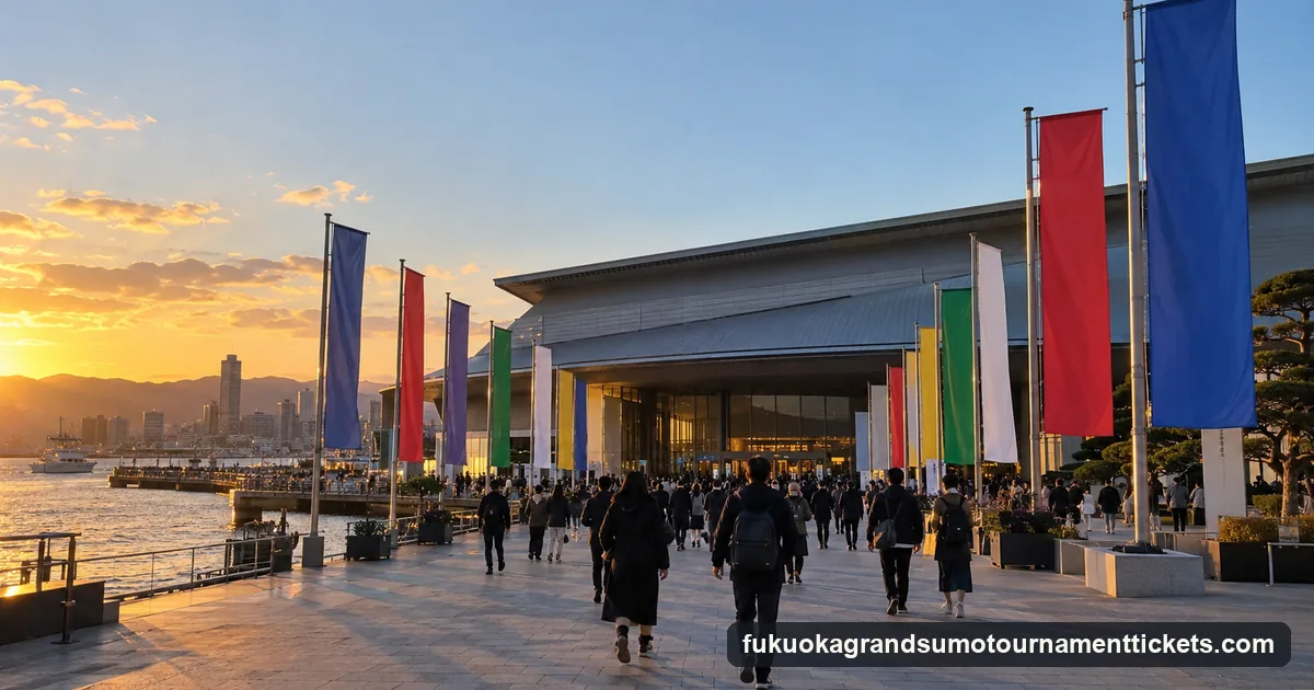 Coloured cloth banners on poles outside a low exhibition hall near a harbour in late afternoon, visitors arriving